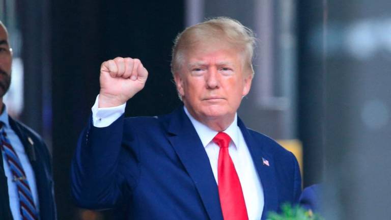 (FILES) In this file photo taken on August 10, 2022 former US President Donald Trump raises his fist while walking to a vehicle outside of Trump Tower in New York City. - AFPPIX