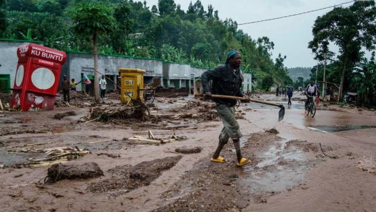 A man removes debris from the flooded road after the flood killed 10 people at the village of Bupfune near Kibuye, in Rwanda’s Western Province, on May 4, 2023. AFPPIX