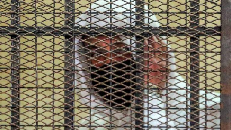 (FILES) In this file photo taken on March 20, 2022 Egyptian media and real estate tycoon Mohamed el-Amin looks from the defendant’s cage during a trial session over charges of “human trafficking” and “sexual assault” in the Egyptian capital’s eastern suburb of New Cairo on March 20, 2022. AFPPIX