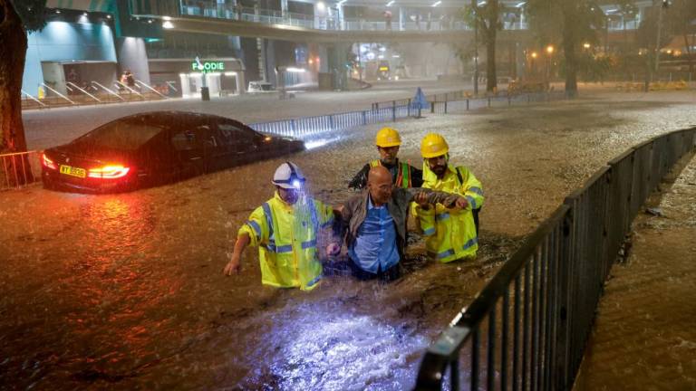 Drainage workers assist a driver stranded due to flooding to a safe place, during heavy rain in Hong Kong, China September 8, 2023. REUTERSPIX