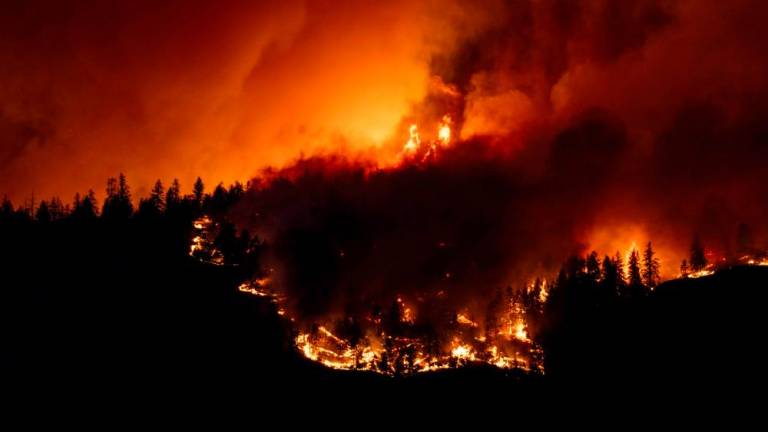 (FILES) The McDougall Creek wildfire burns in the hills West Kelowna, British Columbia, Canada, on August 17, 2023, as seen from Kelowna. AFPPIX