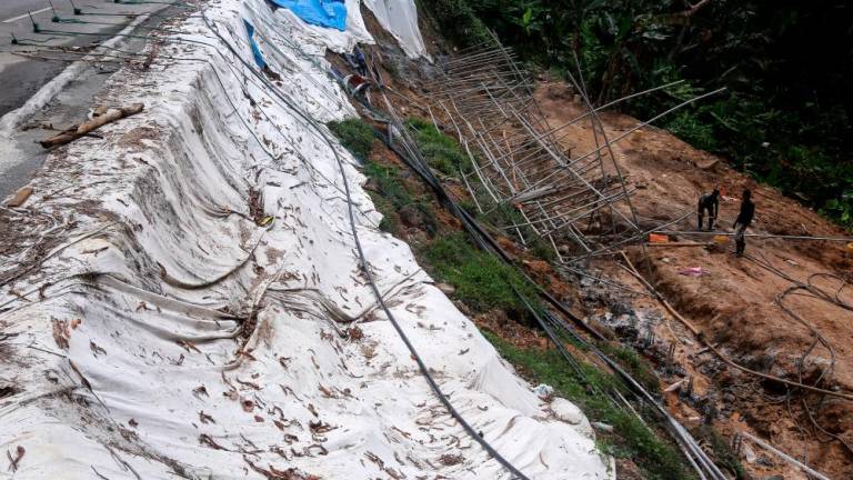 SEREMBAN, Feb 2 -- Two workers are installing construction scaffolding on a slope of land that has collapsed causing cracks in the road on Jalan Persiaran Senawang 3 (N035), today. BERNAMAPIX