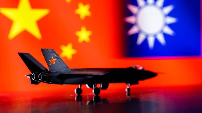 A model of the Chinese Fighter aircraft is seen in front of Chinese and Taiwanese flags in this illustration taken, April 28, 2022. Picture taken April 28, 2022. REUTERSPIX