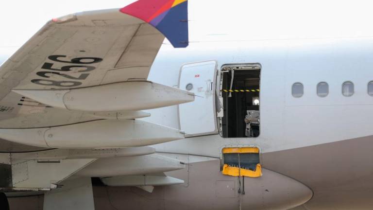 An opened door of an Asiana Airlines plane is seen at Daegu International Airport in Daegu on May 26, 2023, after it was manually opened by a passenger just 200 metres above the ground before landing causing some to have breathing difficulty but with no major injuries. AFPPIX