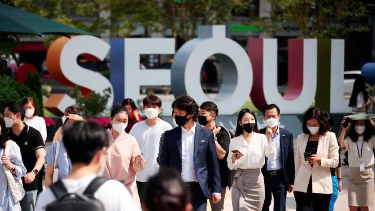 Commuters wearing masks to avoid contracting the coronavirus disease (Covid-19) walk on a zebra crossing in Seoul, South Korea, September 24, 2021. REUTERSpix