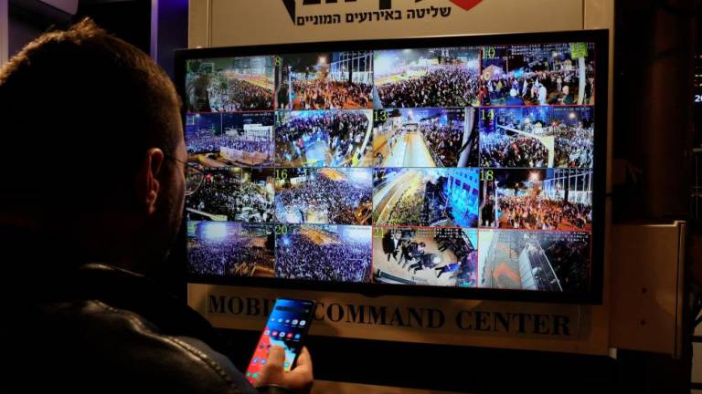 A man stands in front of a monitor showing surveillance camera feeds in Tel Aviv on January 28, 2023 during a protest against controversial government plans to give lawmakers more control of the judicial system. AFPPIX