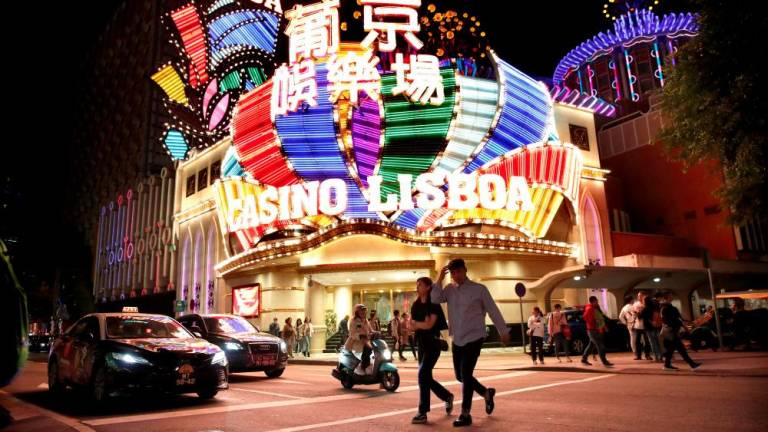 File photo: People walk in front of Casino Lisboa in Macau, China December 21, 2019. REUTERSpix
