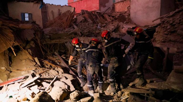 Emergency workers carry a dead body, in the aftermath of a deadly earthquake, in Amizmiz, Morocco, September 10, 2023. REUTERSPIX