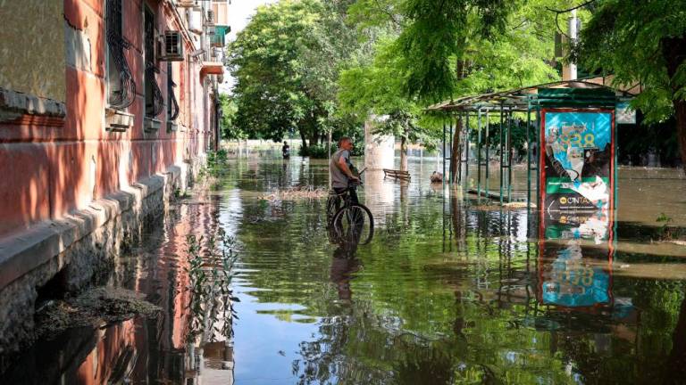 A local resident stands with his bicycle in a flooded street in the town of Kherson, following flooding caused by damage sustained at the Kakhovka HPP dam, on June 6, 2023. AFPPIX