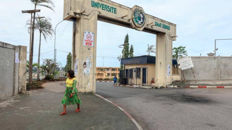 A woman walks past the entrance to the Omar Bongo University complex in Libreville on September 13, 2023. AFPPIX