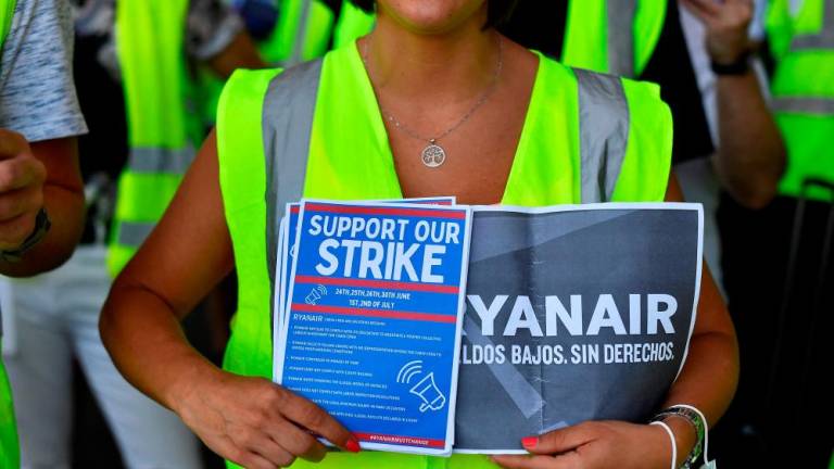 A Ryanair employee holds flyers reading “Support our strike” as they protest at the Terminal 2 of El Prat airport in Barcelona on July 1, 2022. AFPPIX