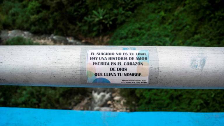 View of a sticker with a religious message which calls for reflection so as not to carry on with suicide, placed at the Miranda viaduct bridge, considered high-risk due to the many suicides committed there, in Merida, Merida state, Venezuela on August 3, 2022. AFPPIX