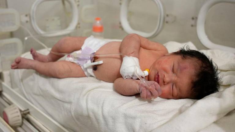 A newborn baby who was found still tied by her umbilical cord to her mother and pulled alive from the rubble of a home in northern Syria following a deadly earthquake, receives medical care at a clinic in Afrin, on February 7, 2023. AFPPIX
