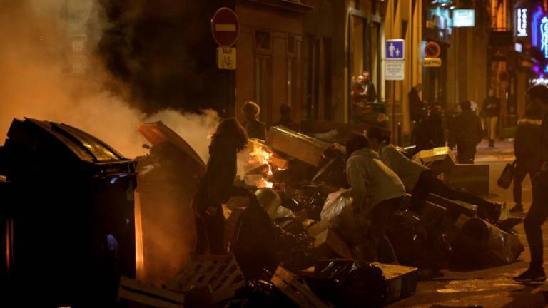 Local residents attempt to take out a waste fire, amid a demonstration, a week after the government pushed a pensions reform through parliament without a vote, using the article 49.3 of the constitution, in Paris on March 23, 2023. AFPPIX