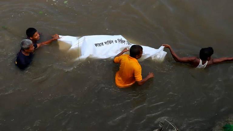 Graphic content - People pull the dead body of a victim who died after a boat capsized in river Karotoa near Boda town on September 26, 2022. AFPPIX