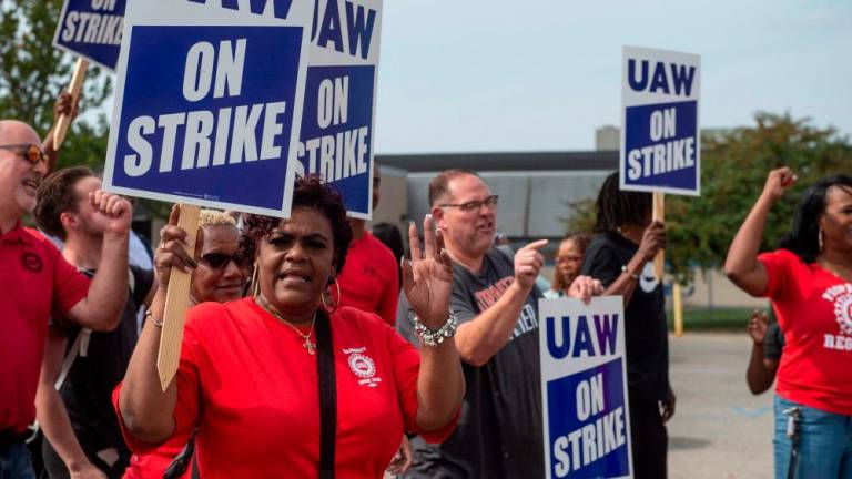 UAW members and workers at the Mopar Parts Center Line, a Stellantis Parts Distribution Center in Center Line, Michigan, hold signs after walking off their jobs at noon on September 22, 2023 and picketed outside the facility. AFPPIX