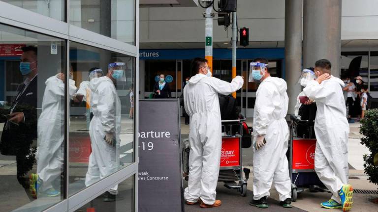 Travellers wear personal protective equipment outside the international terminal at Sydney Airport, as countries react to the new coronavirus Omicron variant amid the coronavirus disease (COVID-19) pandemic, in Sydney, Australia, November 29, 2021. REUTERSPIX