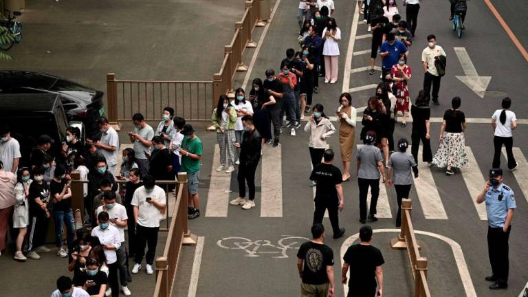 People queue to get tested for the Covid-19 coronavirus at a swab collection site in Beijing on June 9, 2022. - AFPPIX