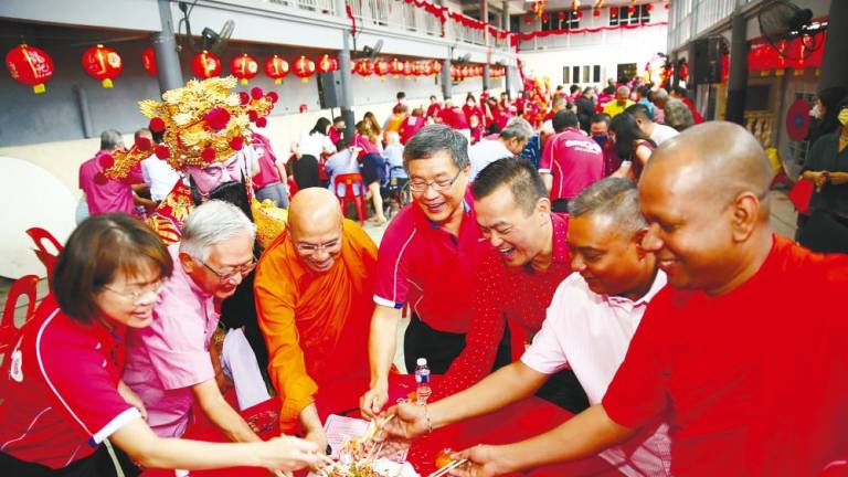 Guests at a recent charity event held in conjunction with Chinese New Year tossing ‘Yee Sang’.