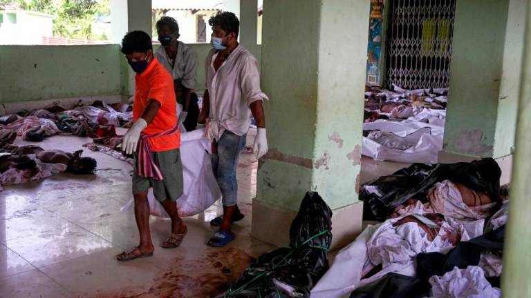 Rescue workers carry the body of a victim at a high school used as temporary mortuary to identify the dead recovered from a carriage wreckage of a three-train collision near Balasore, in India’s eastern state of Odisha, on June 3, 2023/AFPPix