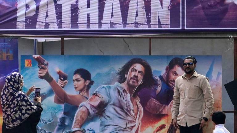 Moviegoers pose for pictures in front of a poster of the Bollywood movie ‘Pathaan’ outside a cinema hall in Prayagraj on January 25, 2023/AFPPix