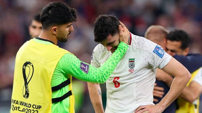 Iran’s midfielder #06 Saeid Ezatolahi (R) cries as he is comforted by Iran’s goalkeeper #22 Amir Abedzadeh at the end of the Qatar 2022 World Cup Group B football match between Iran and USA at the Al-Thumama Stadium in Doha on November 29, 2022/AFPPix