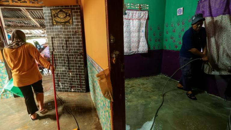 Penduduk Kampung Tenang mencuci kediaman mereka selepas dinaiki air susulan banjir yang melanda beberapa tempat sekitar negeri Johor ketika tinjauan hari ini/fotoBERNAMA