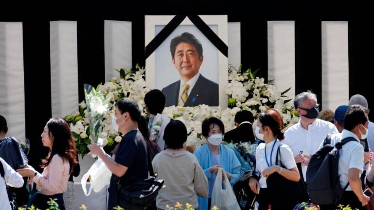 Mourners lay flowers and pay their respects at the altar outside Nippon Budokan Hall, which will host a state funeral for former Prime Minister Shinzo Abe, in Tokyo, Japan September 27, 2022. - REUTERSPIX