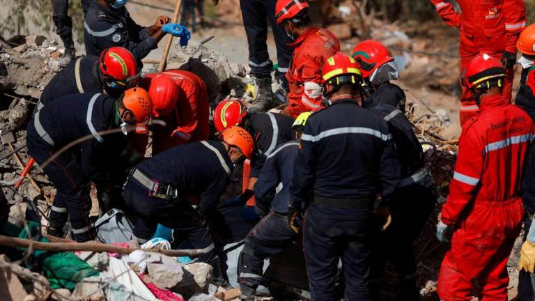 Rescue workers recover a body from under the rubble in the aftermath of a deadly earthquake in Talat N’Yaaqoub, in Morocco September 12, 2023/REUTERSPix