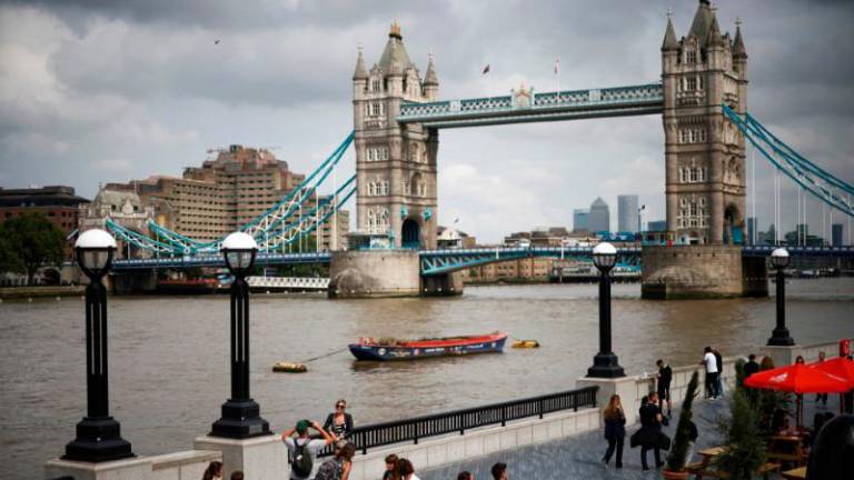File photo: Tower Bridge can be seen as people walk along the River Thames, amid the coronavirus disease (Covid-19) pandemic in London, Britain, July 27, 2021. REUTERSpix