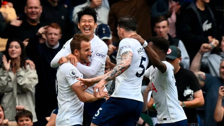 Tottenham Hotspur’s English striker Harry Kane (L) celebrates with teammates after scoring the opening goal from the penalty spot during the English Premier League football match between Tottenham Hotspur and Burnley at Tottenham Hotspur Stadium in London, on May 15, 2022. AFPPIX