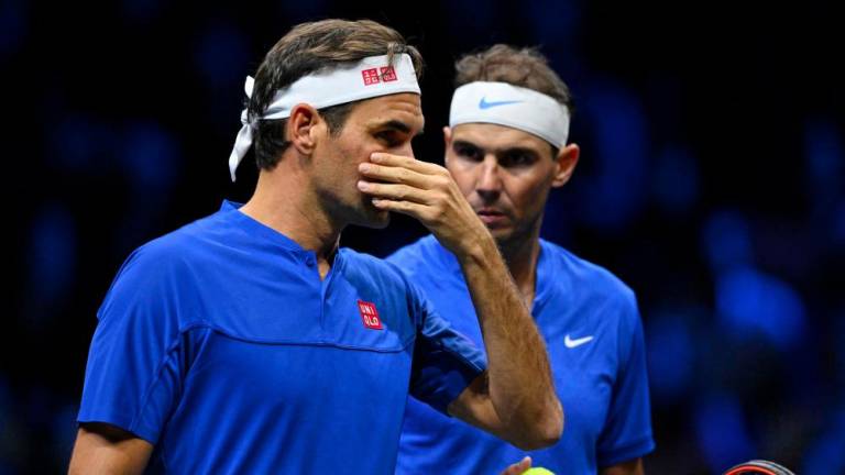 Switzerland's Roger Federer (L) communicates with Spain's Rafael Nadal (R) of Team Europe playing against USA's Jack Sock and USA's Frances Tiafoe of Team World during their 2022 Laver Cup men's doubles tennis match at the O2 Arena in London on September 23, 2022. - AFPPIX
