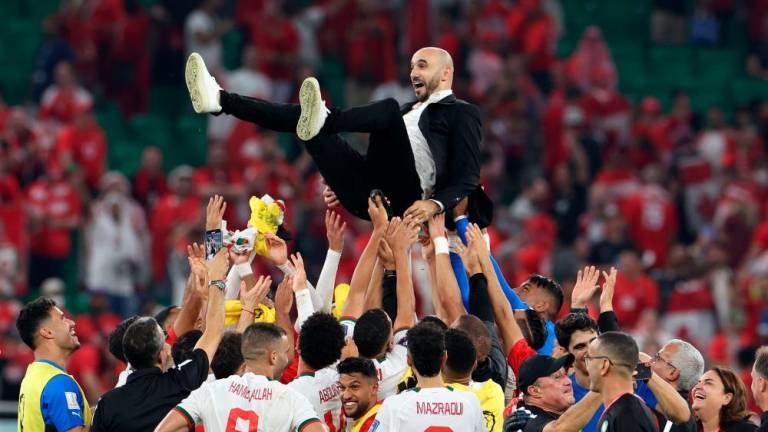 Morocco’s coach #00 Walid Regragui is thrown into the air as his players celebrate winning the Qatar 2022 World Cup Group F football match between Canada and Morocco at the Al-Thumama Stadium in Doha on December 1, 2022. AFPPIX