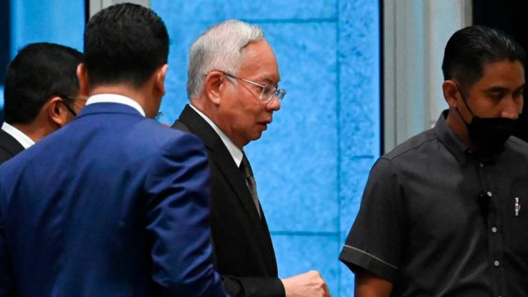 Malaysia's former prime minister Najib Razak (C) walks after a break in his appeal at the federal court in Putrajaya on August 18, 2022. AFPPIX