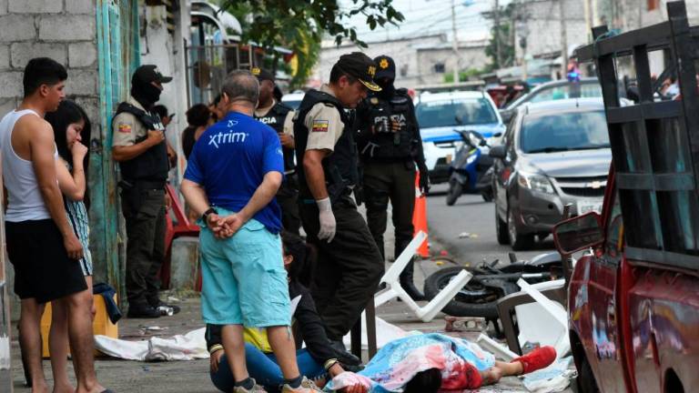 A police expert examines the body of a person killed during a shooting in Guayaquil, Ecuador, on June 4, 2023/AFPPix