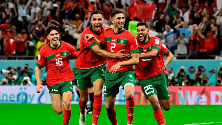 Morocco’s defender #02 Achraf Hakimi (C) celebrates with teammates after converting the last penalty during the penalty shoot-out to win the Qatar 2022 World Cup round of 16 football match between Morocco and Spain at the Education City Stadium in Al-Rayyan, west of Doha on December 6, 2022. AFPPIX