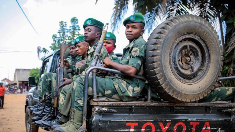 Soldiers of the Armed Forces of the Democratic Republic of Congo (FARDC) are seen on a patrol vehicle in Beni on December 3, 2022. - AFPPIX
