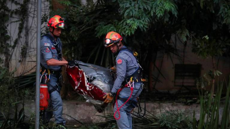 Firefighters carry parts of a helicopter after it crashed in Sao Paulo, killing 4 people according to the authorities, in Sao Paulo, Brazil, March 17, 2023. - REUTERSPIX