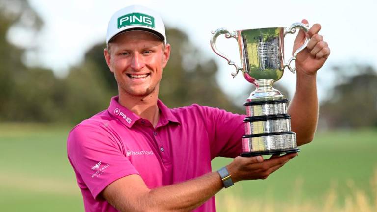 Poland's Adrian Meronk holds the trophy after winning the men's Australian Open golf tournament at the Victoria course in Melbourne on December 4, 2022. - AFPPIX