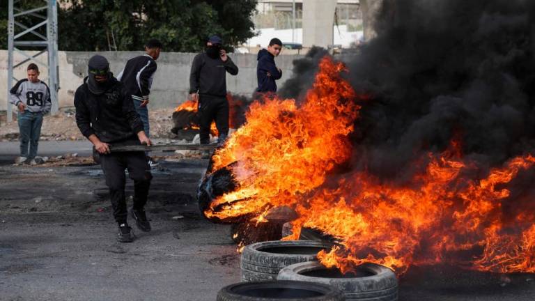 Palestinian protesters burn tyres to block a road leading into Jericho in the occupied West Bank, on February 6, 2023, following a raid in town by Israeli forces. AFPPIX