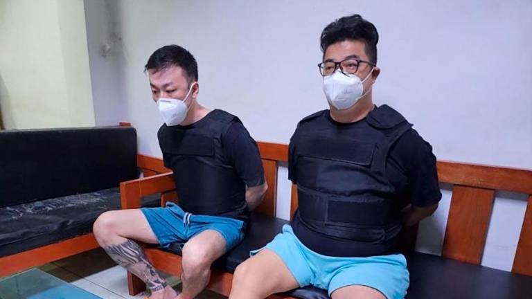 This handout photo taken and released on February 7, 2023 by the Bureau of Immigration shows two suspects believed to be behind a spate of robberies in Japan, Kiyoto Imamura (R) and Toshiya Fujita (L) at the Bureau of Immigration detention facility in Taguig City, suburban Manila. AFPPIX