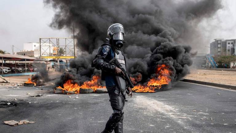 A Senegalese gendarme stand near a smoke billowing from burning tyres during a protest in Dakar on May 29, 2023, over the arrest of opposition leader Ousmane Sonko ahead of the final verdict in his rape trial/AFPpix