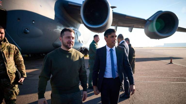 This handout photograph taken and released by the Ukrainian Presidential Press Service on February 8, 2023 shows Britain’s Prime Minister Rishi Sunak (R) welcoming Ukraine’s President Volodymyr Zelensky (L) for a meeting, at the London Stansted Airport. AFPPIX