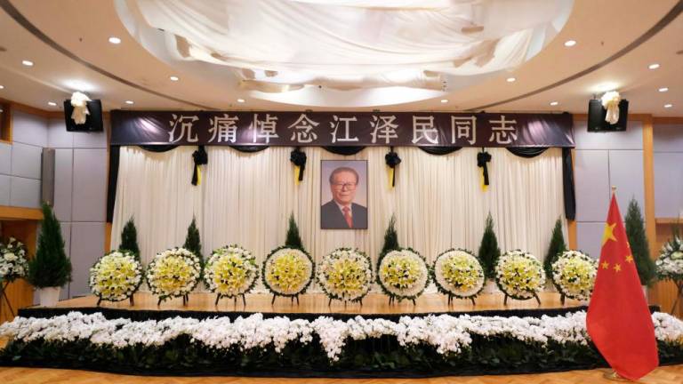 A portrait of former Chinese leader Jiang Zemin (C) is displayed at the Chinese Liaison Office in Hong Kong on December 1, 2022, following Jiang’s death on November 30 aged 96/AFPPix