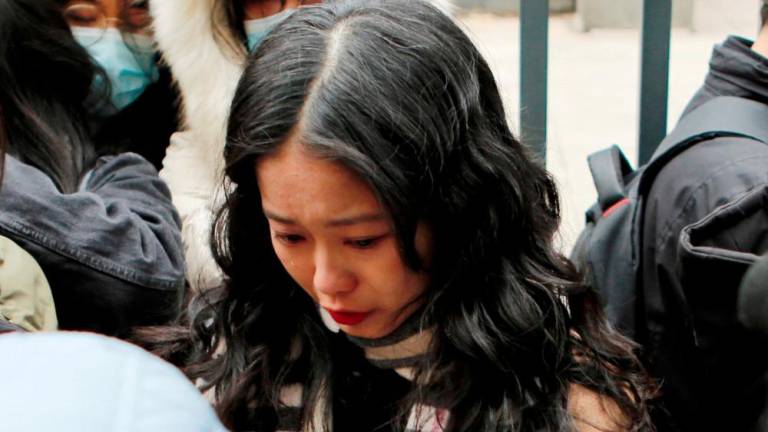 FILE PHOTO: Zhou Xiaoxuan, also known by her online name Xianzi, weeps as she arrives at a court for a sexual harassment case involving a Chinese state TV host, in Beijing, China December 2, 2020. - REUTERSPIX