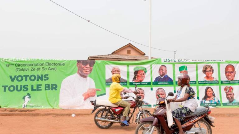 Motorcyclists drive past banners of thr Republican Bloc (BR) party in Abomey Calavi on January 6, 2023. Benin goes to the polls on January 8, 2023 for a legislative ballot marked by the opposition’s electoral return following a de-facto ban four years ago. AFPPIX