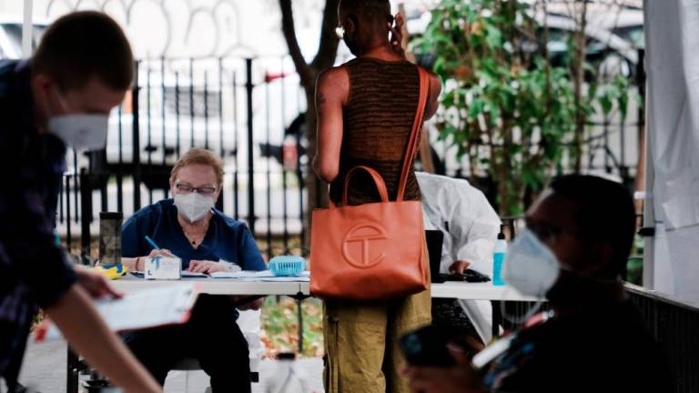 NEW YORK, NEW YORK - JULY 29: Healthcare workers with New York City Department of Health and Mental Hygiene work at intake tents where individuals are registered to receive the monkeypox vaccine on July 29, 2022 in New York City. AFPPIX