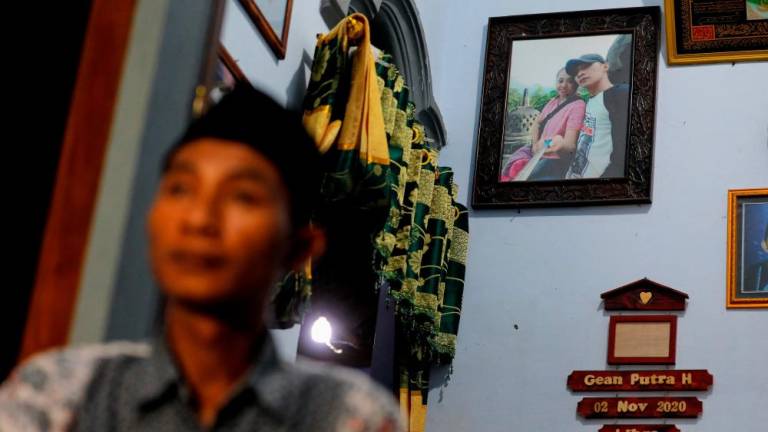 A picture of Andi Hariyanto and his late wife Gebi Asta Putri Purwoko, who died in a recent riot and stampede following a soccer match between Arema FC and Persebaya Surabaya at Kanjuruhan stadium, hangs on a wall at his house in Malang, East Java province, Indonesia, October 4, 2022. REUTERSPIX