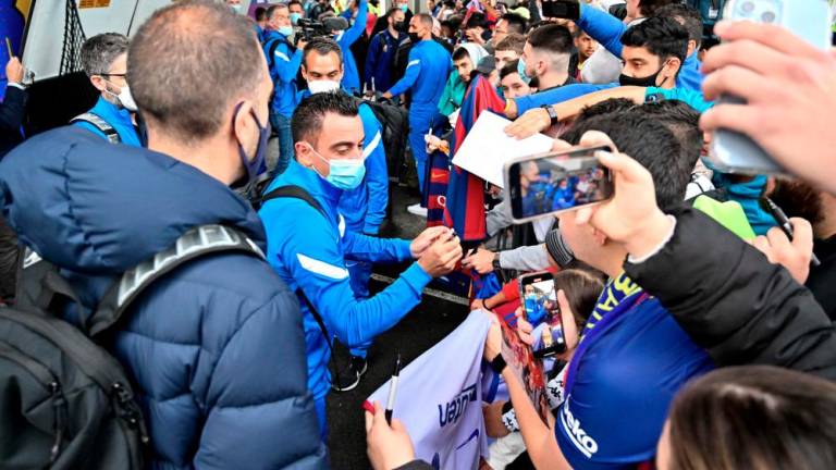Head Coach Xavi Hernandez (L) of FC Barcelona signs autographs to fans at Sydney International Airport on May 24, 2022, on the eve of their friendly match against A-League All Stars team in Sydney. AFPPIX