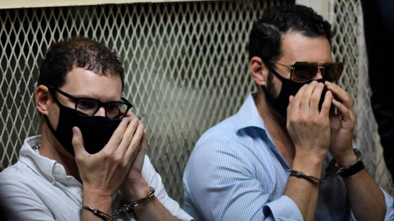 (FILES) In this file photo taken on July 06, 2020 Luis Enrique Martinelli (L) and Ricardo Martinelli Jr., sons of Panamanian former president (2009-2014) Ricardo Martinelli, remain handcuffed after being arrested in Guatemala City. AFPPIX